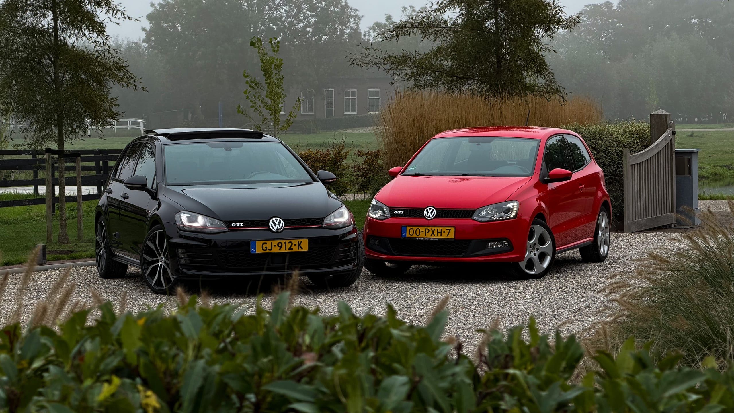 Een zwarte Volkswagen Golf GTI en een rode Volkswagen Polo GTI naast elkaar op een grindpad